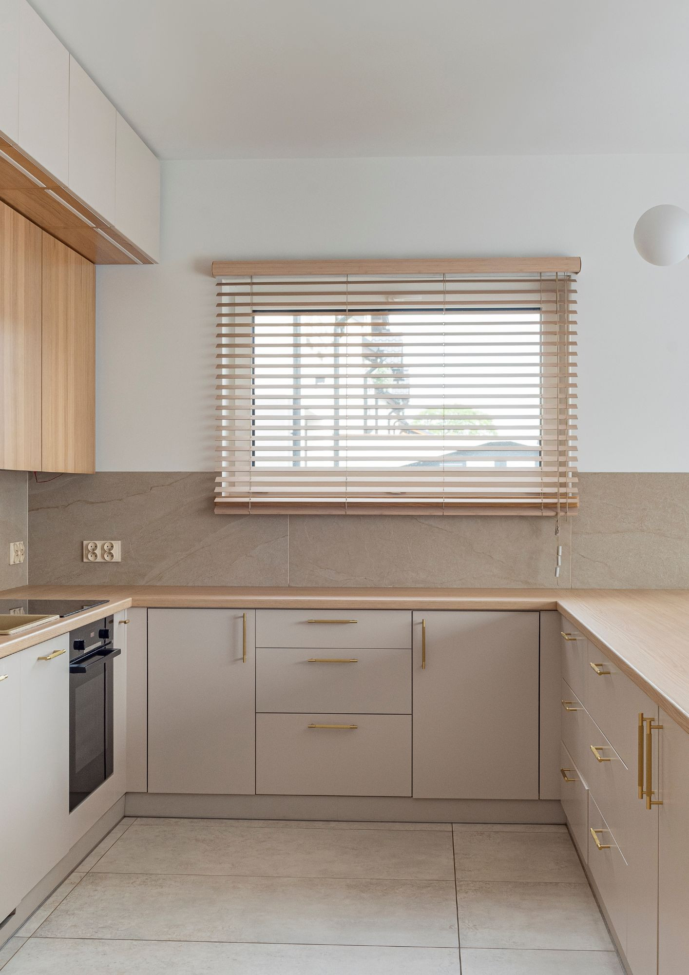 Minimalistyczna kuchnia na wymiar Leszno – drewniany blat, beżowe fronty i nowoczesny design.