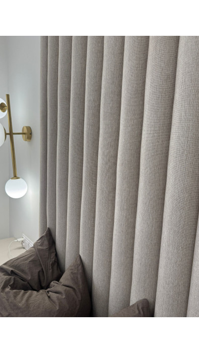 A modern bed with an upholstered headboard and grooved nightstands