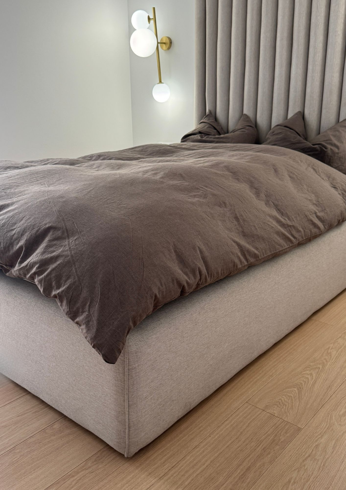Beige panel bed with a high headboard for the bedroom