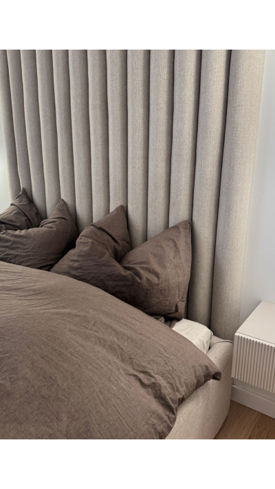 A bedroom bed with hotel-style upholstered panels