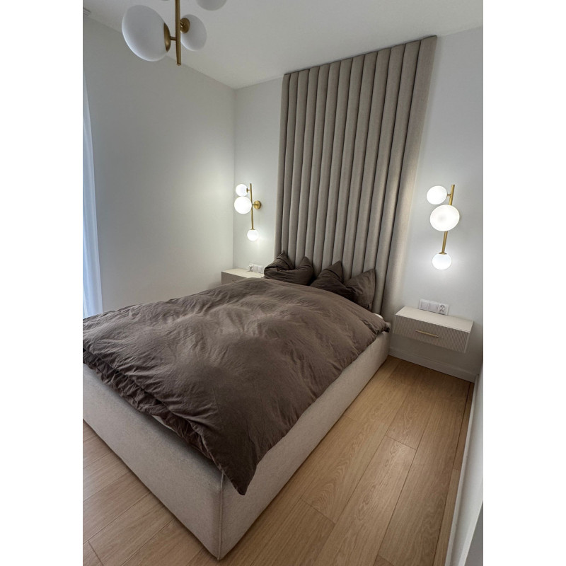 Łóżko z pionowymi panelami tapicerowanymi na ścianie Łóżko z pionowymi panelami tapicerowanymi na ścianie