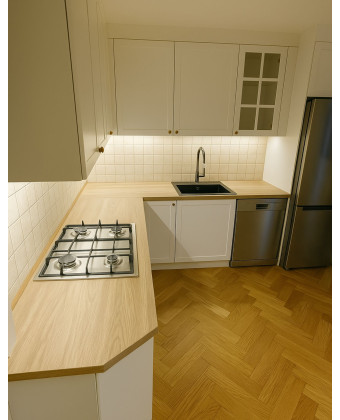 A modern, custom-made Provencal kitchen with a gas stove, a wooden countertop, and custom cabinets.