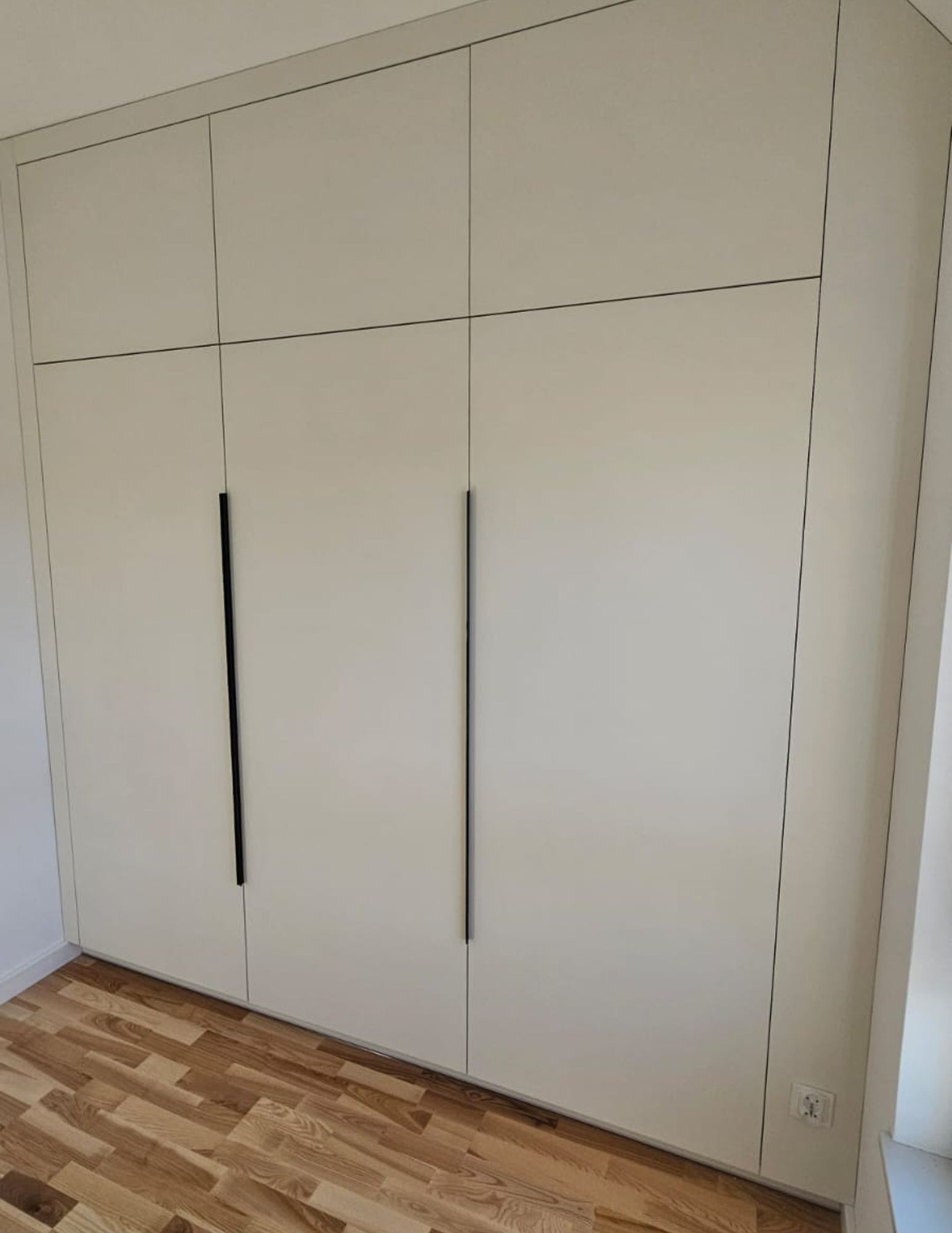 Wardrobe with black handles – a minimalist, custom-made wardrobe for a bedroom or walk-in closet. Wardrobe with black handles – a minimalist, custom-made wardrobe for a bedroom or walk-in closet.