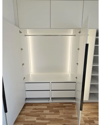 Wardrobe with black handles – a minimalist, custom-made wardrobe for a bedroom or walk-in closet.