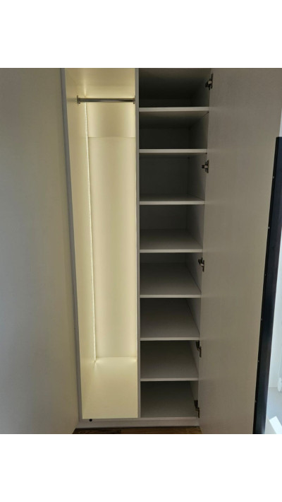 A white custom-made wardrobe with tall black handles—an elegant and functional storage solution. A white custom-made wardrobe with tall black handles—an elegant and functional storage solution.