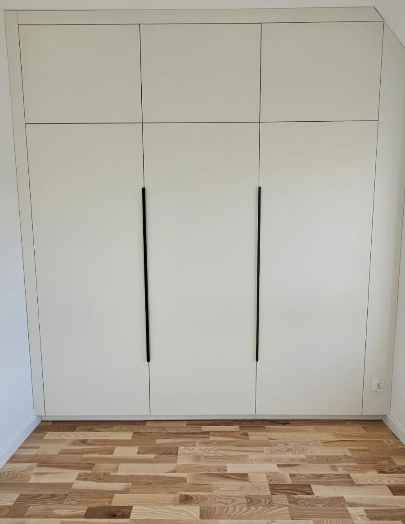 A minimalist built-in wardrobe—lacquered doors, built all the way up to the ceiling. A minimalist built-in wardrobe—lacquered doors, built all the way up to the ceiling.