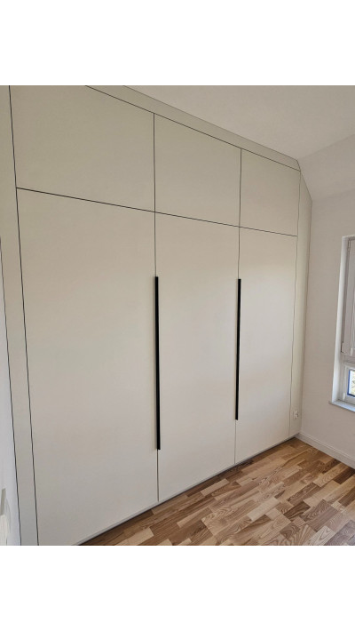 A wardrobe with vertical black handles and a white interior—perfect for modern spaces. A wardrobe with vertical black handles and a white interior—perfect for modern spaces.