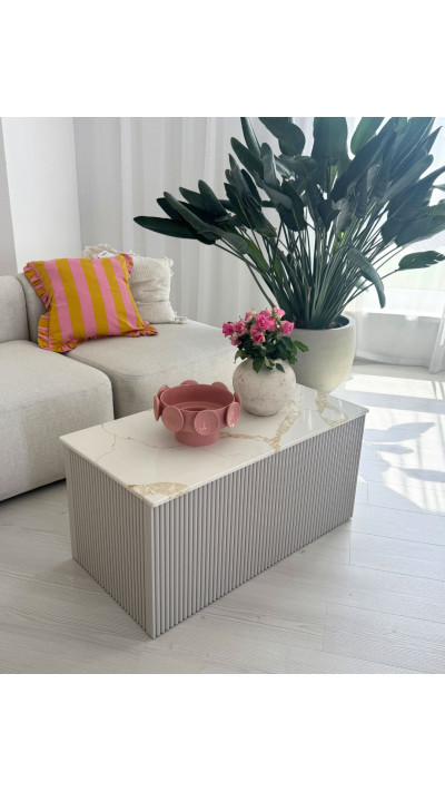 Ryflowany stolik kawowy z jasnym blatem ze spieku kwarcowego – elegancki mebel do salonu. Ryflowany stolik kawowy z jasnym blatem ze spieku kwarcowego – elegancki mebel do salonu.
