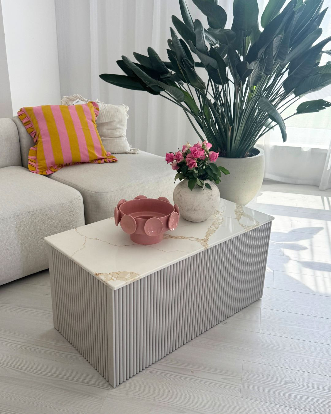 Ryflowany stolik kawowy z jasnym blatem ze spieku kwarcowego – elegancki mebel do salonu. Ryflowany stolik kawowy z jasnym blatem ze spieku kwarcowego – elegancki mebel do salonu.