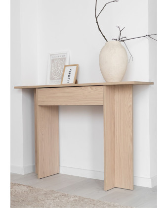 A narrow wall-mounted console table with a drawer in a light wood finish