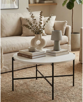Round side table with a white tabletop and metal base – a minimalist coffee table for the living room