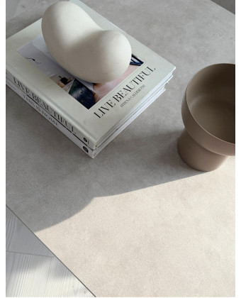 The Ferrera coffee table with a gold metal frame and a light-colored tabletop in a minimalist living room The Ferrera coffee table with a gold metal frame and a light-colored tabletop in a minimalist living room