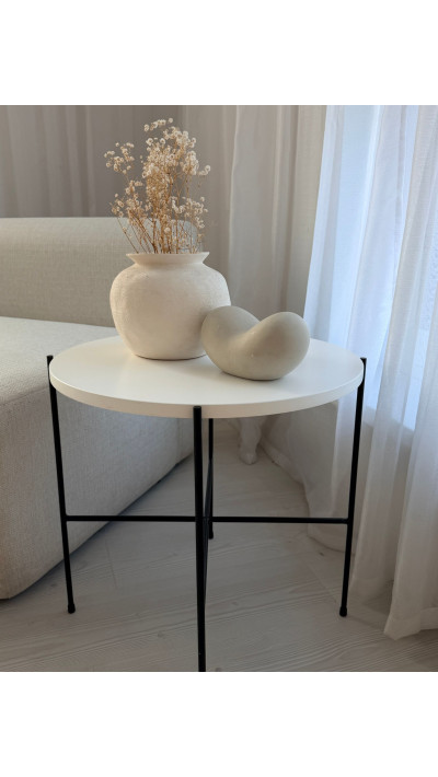 Round white coffee table with black legs, minimalist living room table, loft and Japandi styles Round white coffee table with black legs, minimalist living room table, loft and Japandi styles