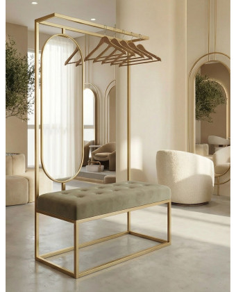 Złoty wieszak stojący z owalnym lustrem i welurowym siedziskiem w luksusowej poczekalni salonu kosmetycznego