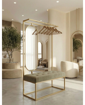 Złoty wieszak stojący z owalnym lustrem i welurowym siedziskiem w luksusowej poczekalni salonu kosmetycznego