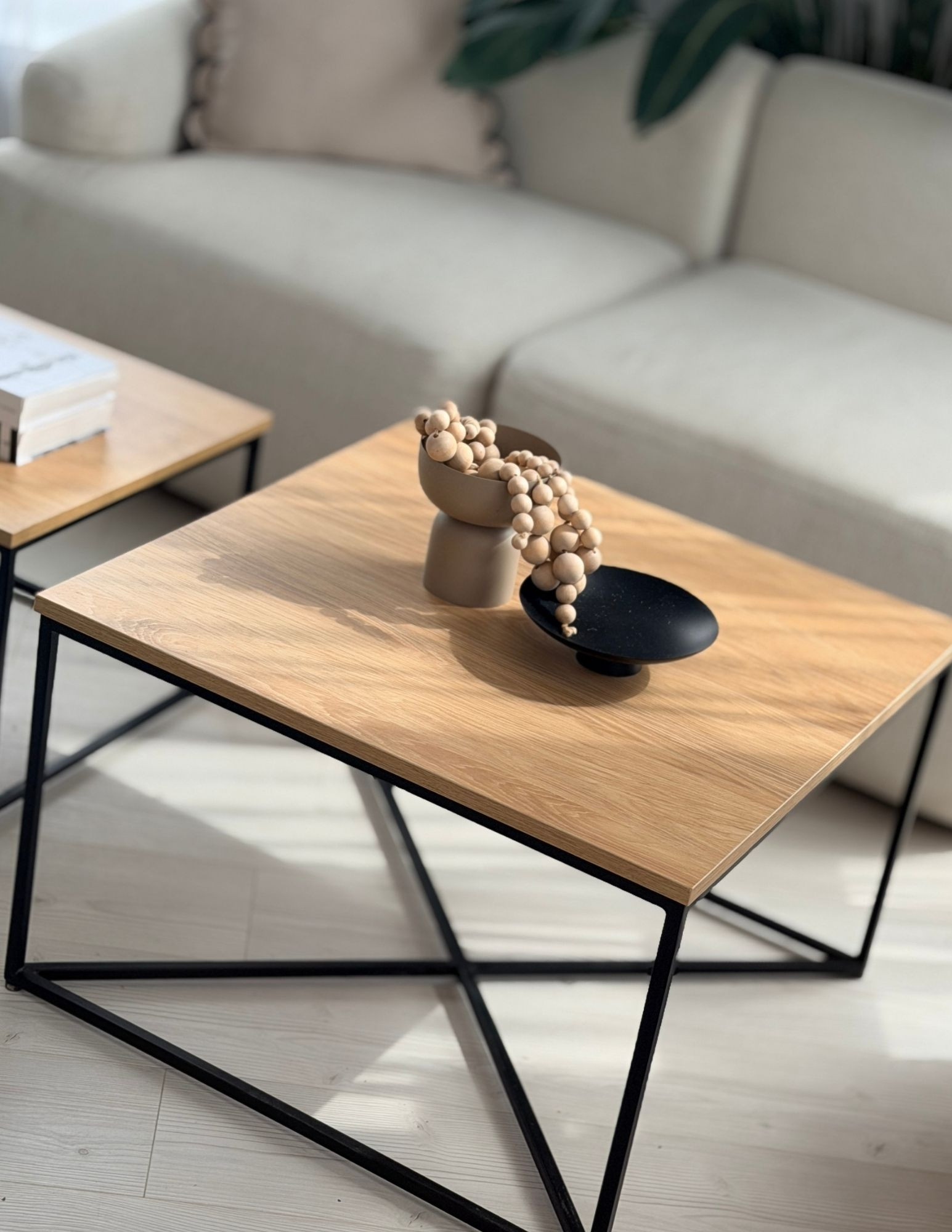 two wooden coffee tables with black metal frames for the living room