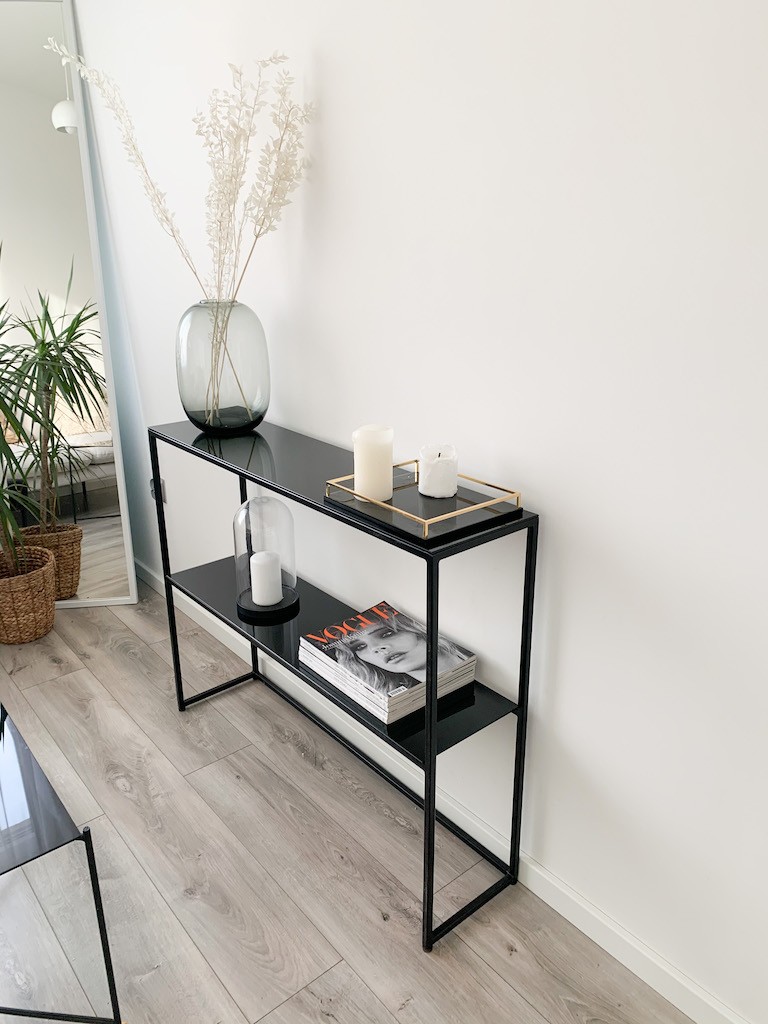 Minimalistyczna czarna konsola ZENOBIA z dekoracjami – świece, tace, wazony